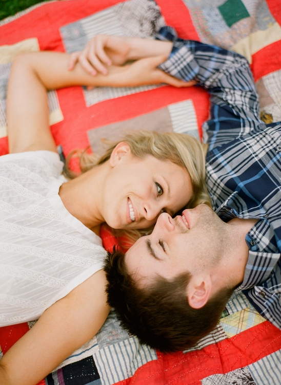 Couple cuddling on quilt, happy loving faces