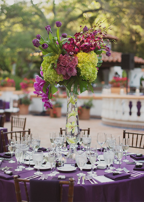 Purple themed wedding table setting with flower centerpiece