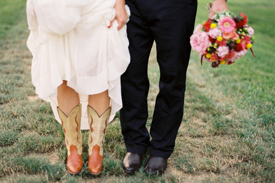 Bride in cowboy boots at her wedding holding bouquet