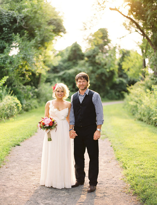 Bride and groom holding hands in a rustic wedding setting