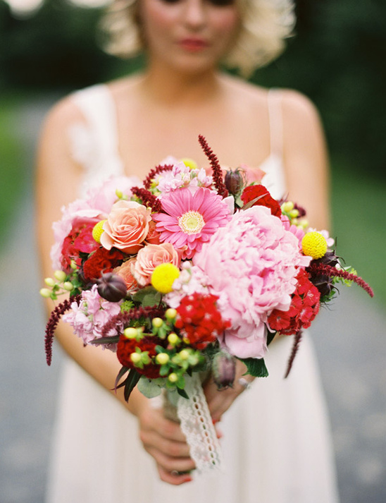 Bride holding a colorful pink and red wedding bouquet