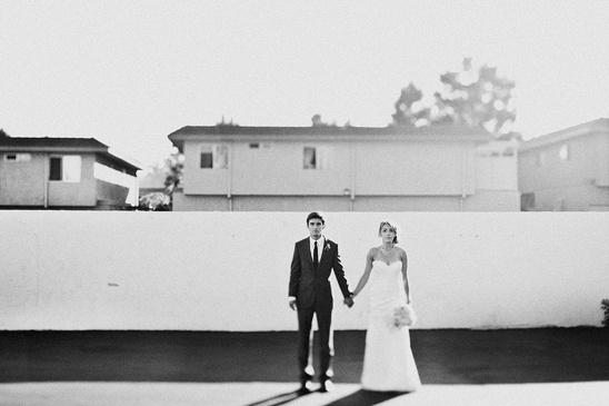 Black and white photo of bride and groom holding hands