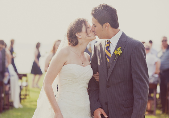 Bride and groom share a kiss at their outdoor wedding