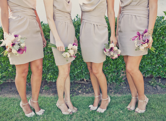 Four bridesmaids in taupe dresses with bouquets