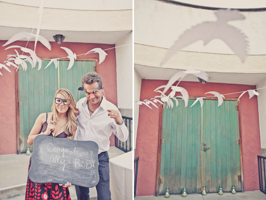 Couple poses with chalkboard sign, party decorations