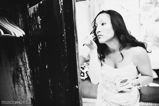 Woman applies makeup in mirror black and white