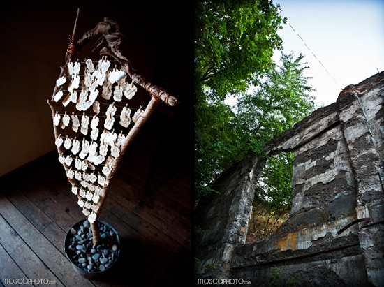 Artistic display with tags by stone wall and green trees