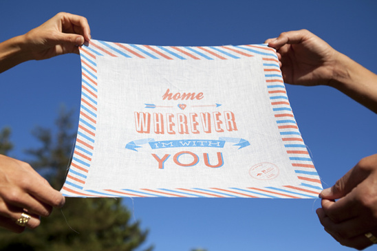 Hands holding a fabric with the message Home Wherever Im With You