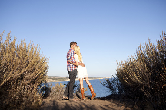Couple hugging on cliff overlooking the ocean, romantic and serene scene