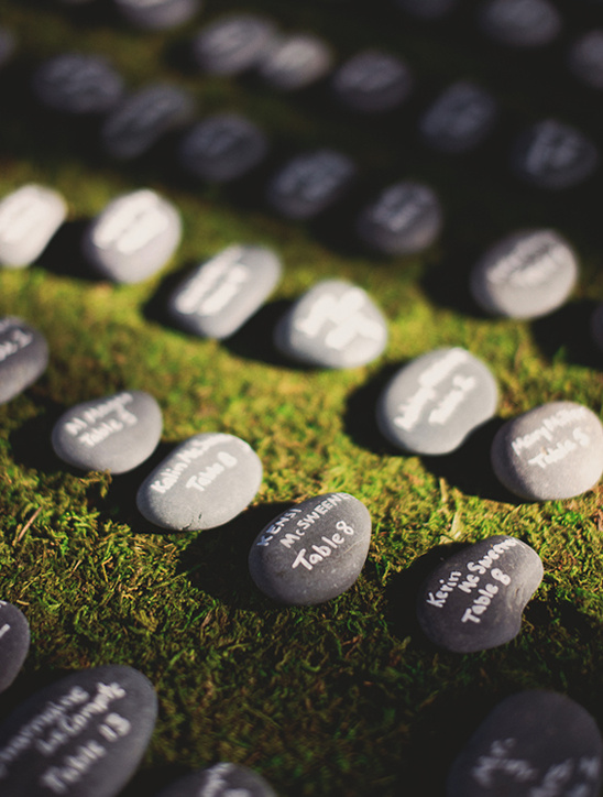 Wedding seating arrangement using personalized engraved stones on green grass