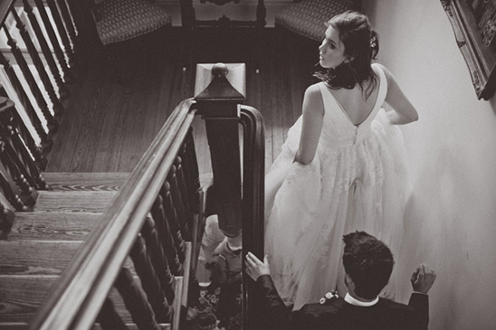 Bride walking down stairs on wedding day, groom looks up