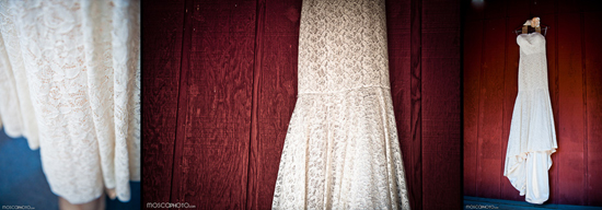 Elegant white lace wedding dress hanging on red wood background