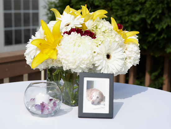 Floral arrangement with a photo and candle on a white table