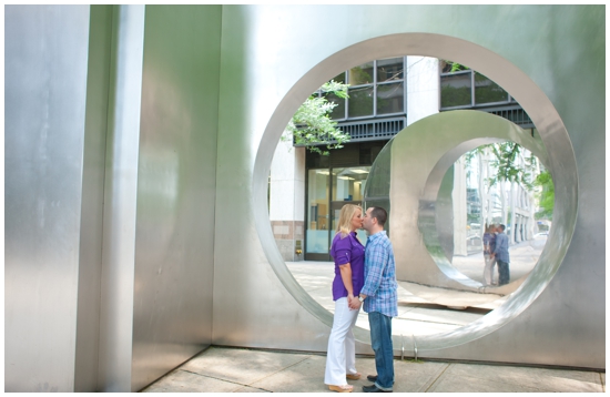 Couple kissing in modern art sculpture, outdoor engagement photos