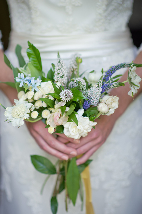 Bride holding a beautiful wedding bouquet with white and blue flowers