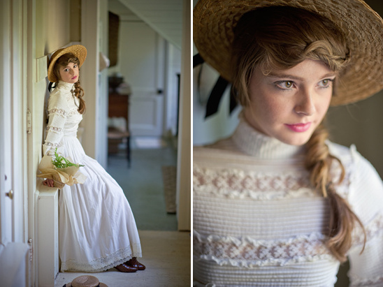 Woman in vintage dress and hat leaning indoors with flowers