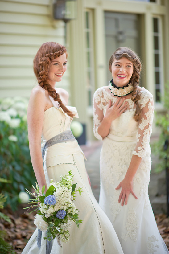 Two smiling brides in white dresses with beautiful braided hair