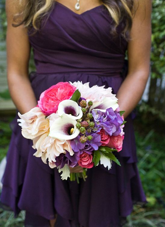 Woman in purple dress holding a vibrant bouquet of flowers