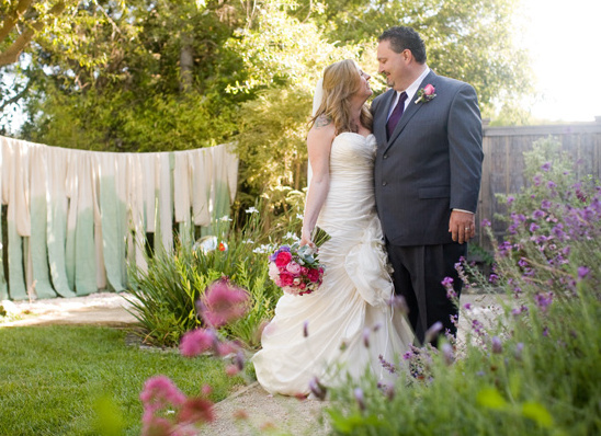 Happy couple embracing on their wedding day in a garden setting