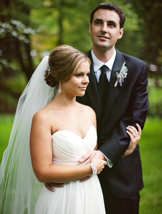 Bride and groom pose together on their wedding day in a garden