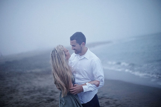 Couple embracing on a foggy beach, romantic and tender moment