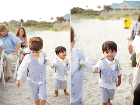 Two adorable ring bearers walking down the beach aisle for a wedding
