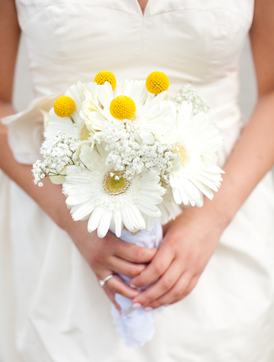 Bride holding a beautiful white and yellow flower bouquet at her wedding