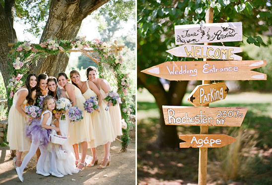 Bridesmaids smile for the camera with a sign that leads to the wedding entrance