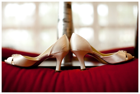 Elegant ivory wedding shoes on a rich red background for a special occasion