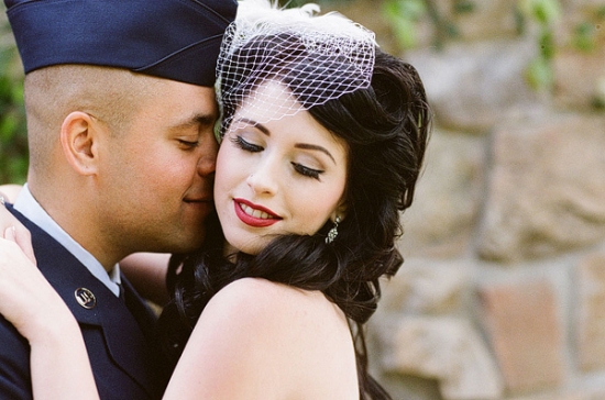 Smiling couple embracing, in vintage wedding attire, close together