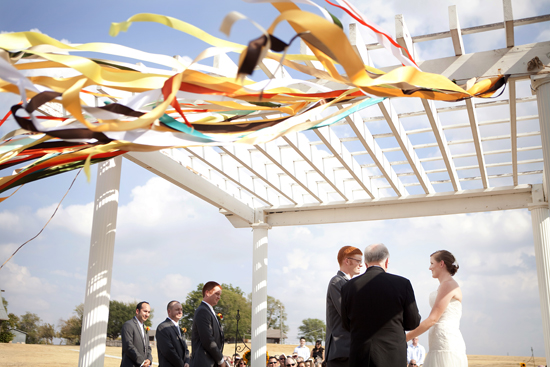 Bride and groom at outdoor wedding ceremony arbor