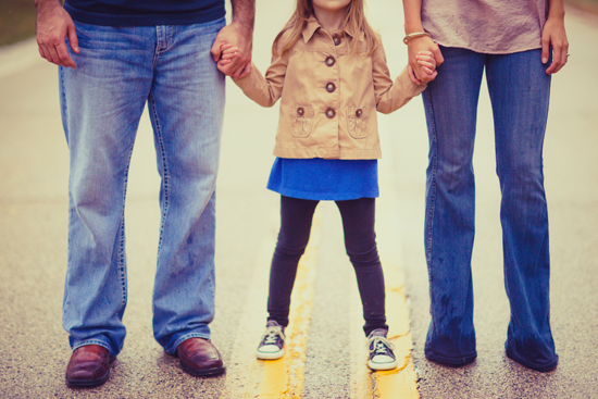Family holding hands, walking down the street together