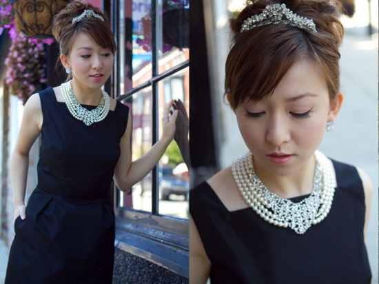 Woman in classic black dress with pearl necklace and headpiece