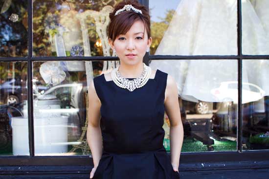 Woman dressed as Audrey Hepburn in front of a shop window