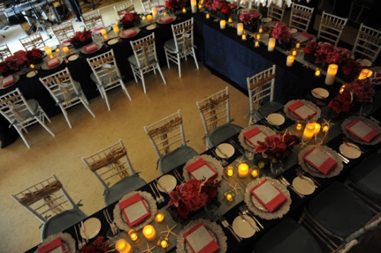 Elegant wedding tablescape decorated with candles and red flowers