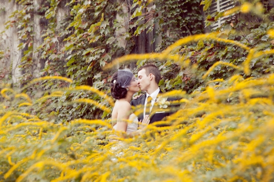 Romantic wedding kiss captured in a field of golden yellow flowers