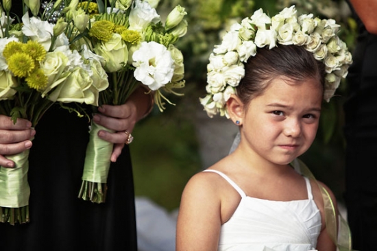 Flower girl with a skeptical expression at a wedding