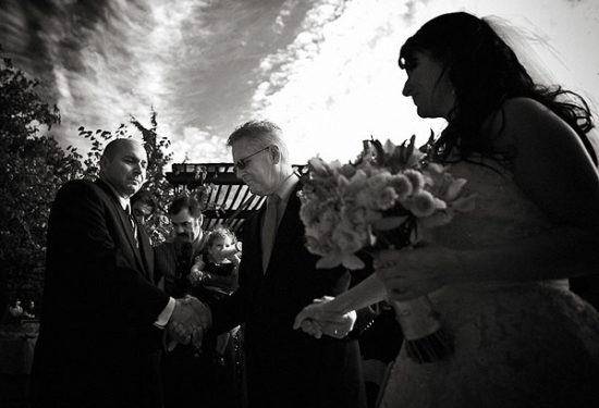 Father gives away bride at outdoor wedding ceremony