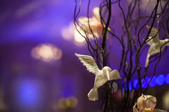 Silver hummingbird decor on dark branches with purple background