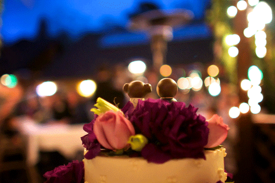 Wedding cake with flowers and decorative topper at night