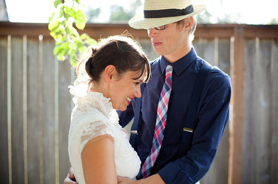 Happy bride and groom embracing outdoors, smiling in sunshine