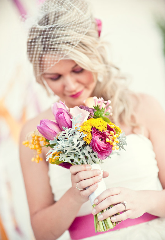Bride in veil holding colorful wedding bouquet close-up