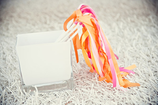 White box filled with colorful ribbons on a fluffy rug