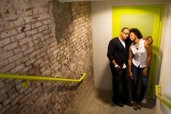 Loving couple embracing in a modern urban setting near a brick wall