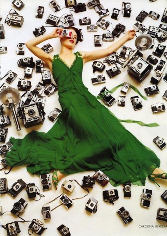 Woman in green dress among vintage cameras