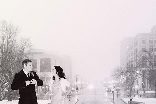 Newlyweds embrace on a snowy city street, celebrating their wedding day