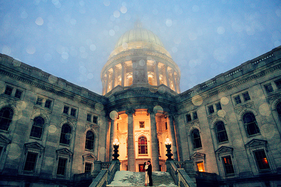 Wedding couple embraces in front of illuminated capitol building