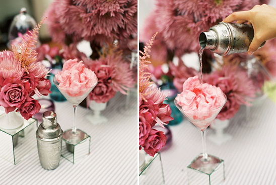 Pink cocktail being poured with floral arrangements