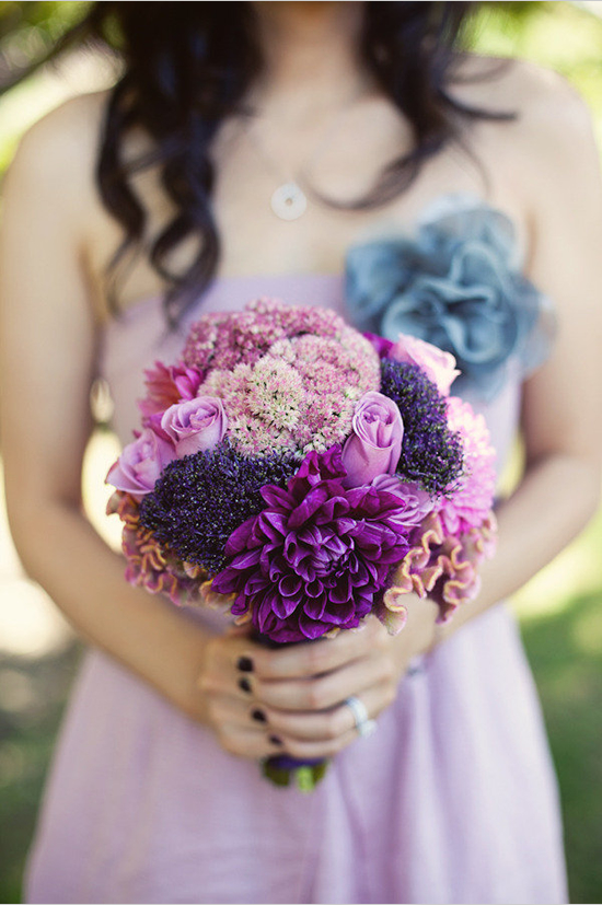Purple floral bouquet held by bridesmaid