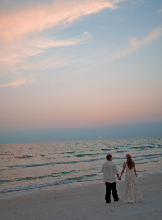 Couple holding hands beach sunset